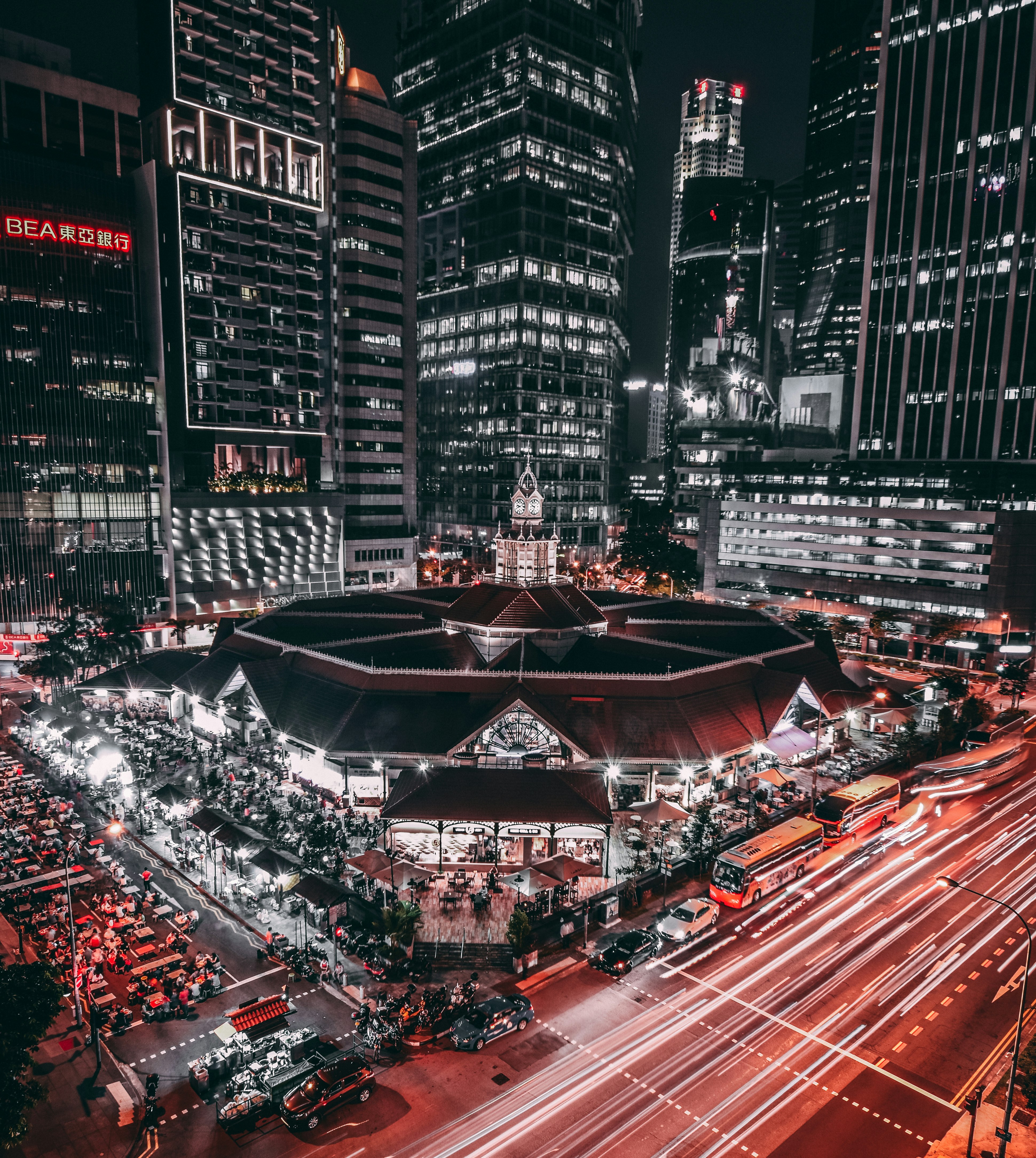 black and white lighted building surrounded by vehicles